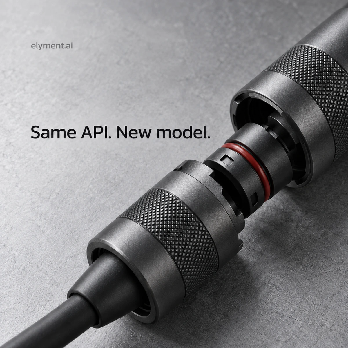 Conceptual silver-grey editorial photograph of a graphite cable connector with a removable inner cartridge, illustrating a changed model behind the same interface.